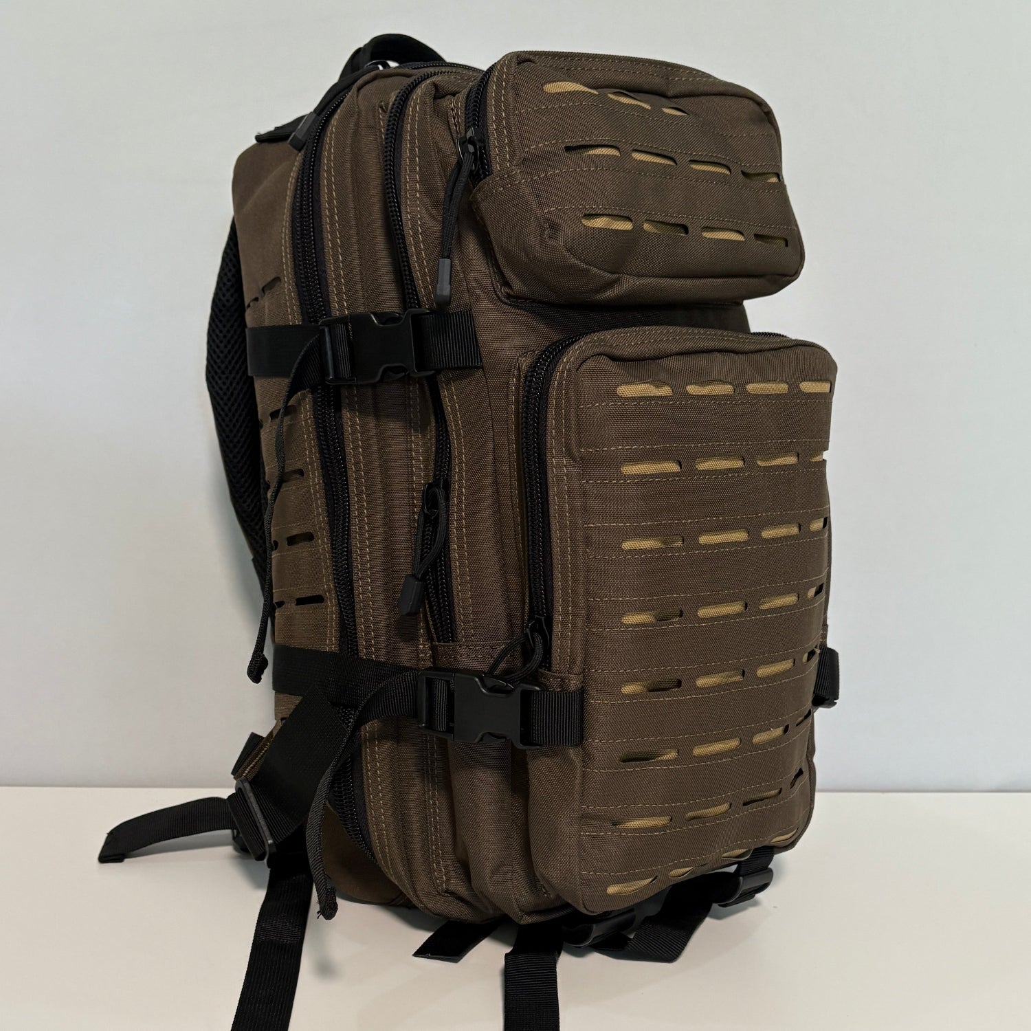 Brown tactical backpack on a white surface with a 'Holy Molle' logo in the corner.