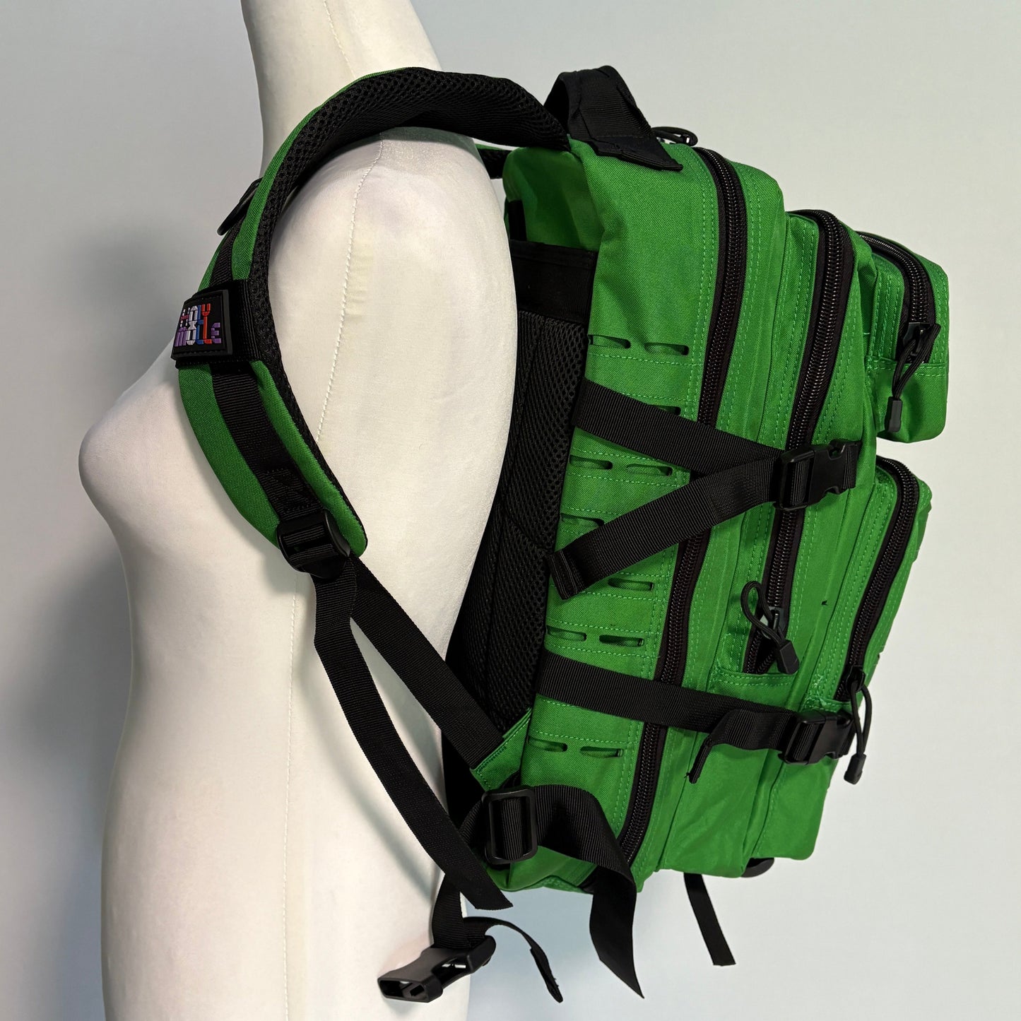 Green tactical backpack on a mannequin with a plain background