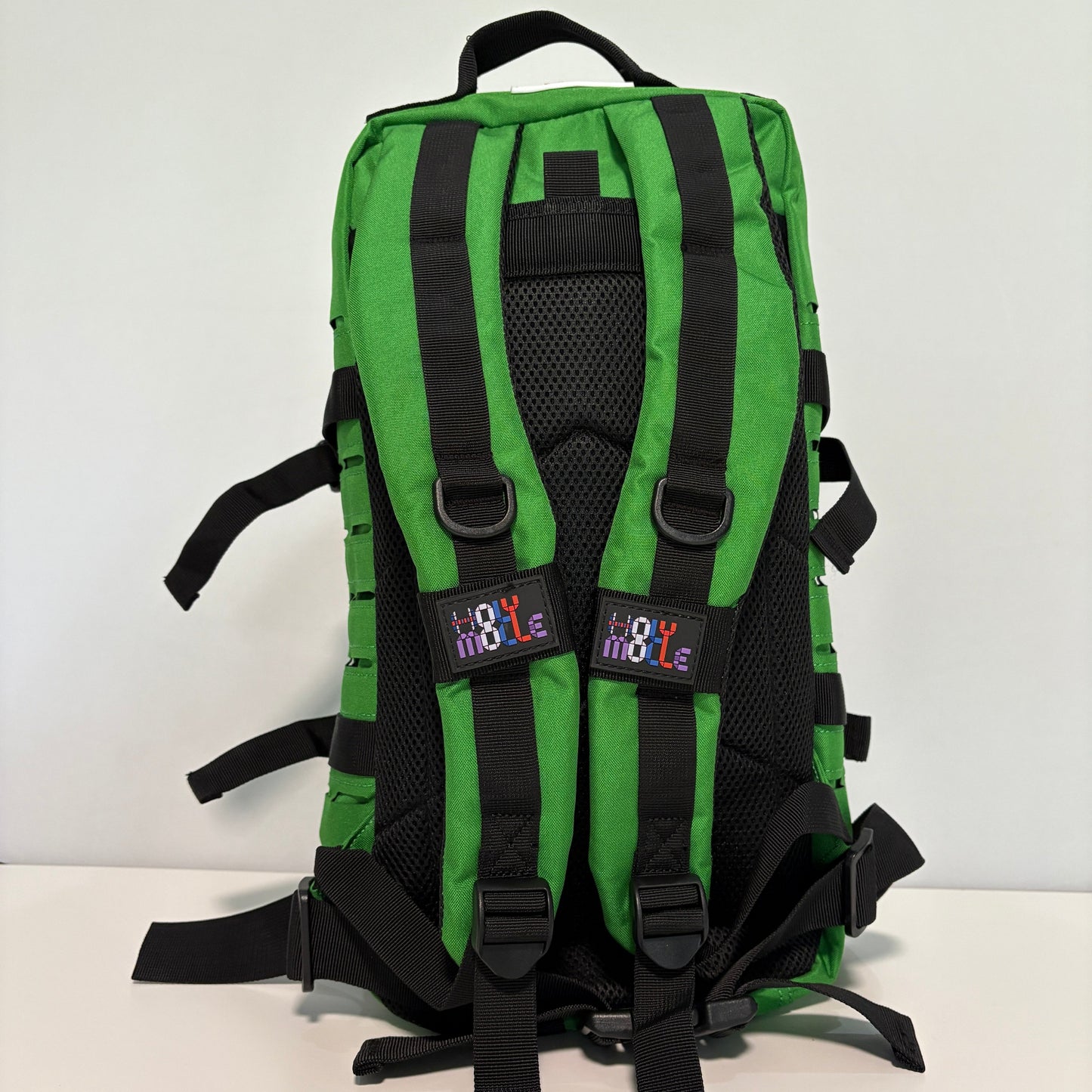 Green backpack with black straps on a white background
