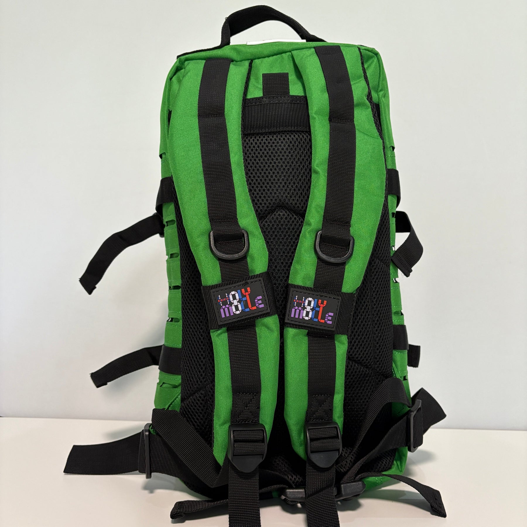 Green backpack with black straps on a white background